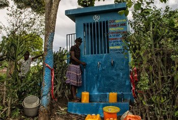 A woman along with her son, fills her containers at a water distribution point in Las Palmas, Haiti. Logan Abassi/UN/MINUSTAH
