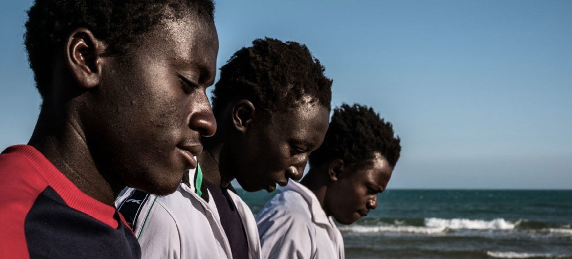 A group of Gambian boys survey the ocean from the beach during an outing from a Government reception centre that doubles as a lodging station for unaccompanied minors in Pozzallo, Sicily, on May 17, 2016.
