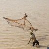 un pêcheur jetant son filet dans le bassin d'Arikouka, à Tera, au Niger.