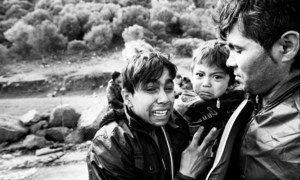 With fear etched on their faces, clearly still suffering from the trauma of a rough by boat across the Aegean, an Afghan family arrives in Lesbos, Greece (2015).