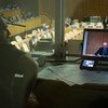 El intérprete de la ONU Nicolás Diaz realiza una traducción simultánea al español de las palabras del enviado especial de la ONU para Siria, Staffan de Mistura (en pantalla), en la Asamblea General de la ONU. Foto: ONU/Mark Garten