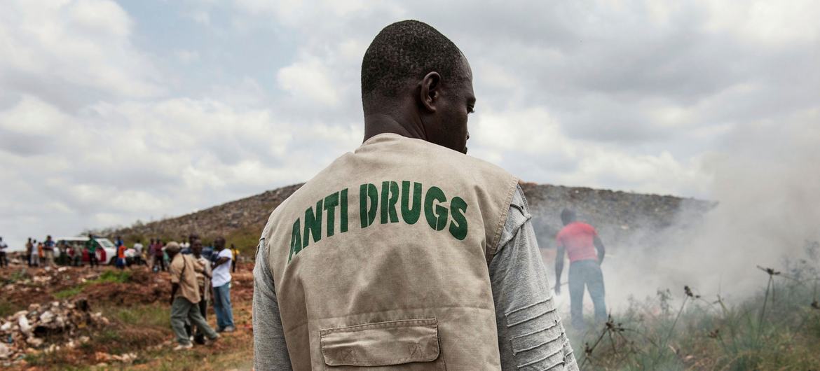 A staff member of the Liberia National Police Anti-Drug Squad reviews the municipal dump outside Monrovia, Liberia.