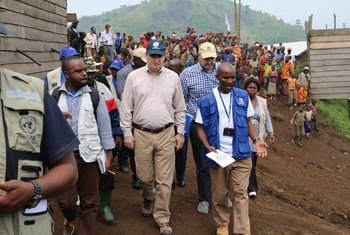 Operations Director of the Office of the Coordination of Humanitarian Affairs (OCHA), John Ging (centre), walks around the Kanaba IDP site in the Democratic Republic of the Congo (DRC) during a visit on 24 June 2016.