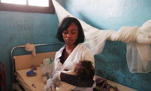Une infirmière à l'hôpital de Kahemba, en RDC, s'occupe d'un enfant dont la mère, atteinte sans doute de la fièvre jaune, est décédée après être arrivée à l'hôpital. Photo OMS/A. Clements-Hunt