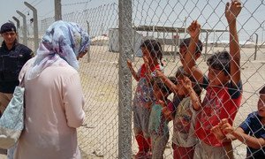 In Iraq, a UNICEF child protection staff member speaks to children who are staying in the Amiriyat Al Fallujah IDP camp in the province of Anbar that has been established for internally displaced persons fleeing conflict in Fallujah.