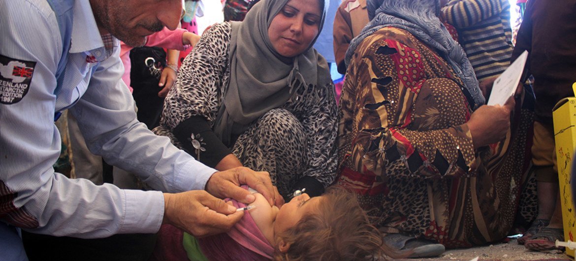 Health workers vaccinate a child in a medical centre in Al-Radwanieh village, rural Aleppo.