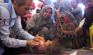 Health workers vaccinate a child in a medical centre in Al-Radwanieh village, rural Aleppo.