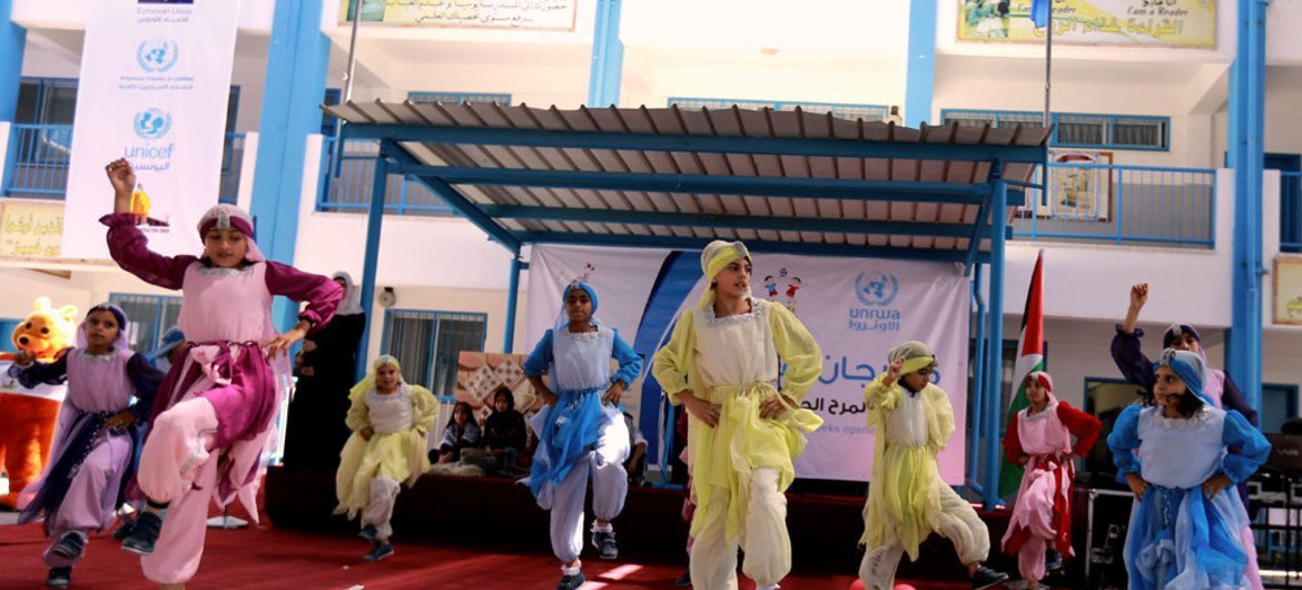 أطفال من لاجئي فلسطين يرقصون الدبكةأثناء افتتاح أسابيع المرح.