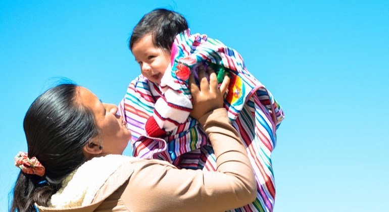 Una mujer peruana sujeta a su bebé. 