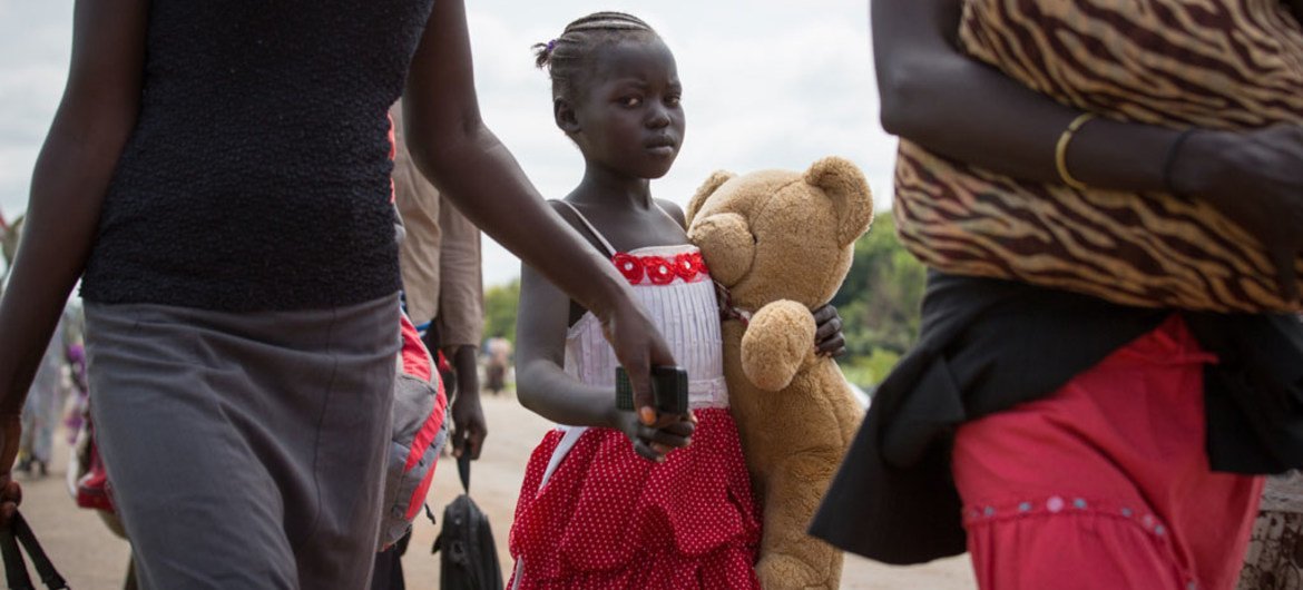 A young refugee and her family cross the border between South Sudan and Uganda.