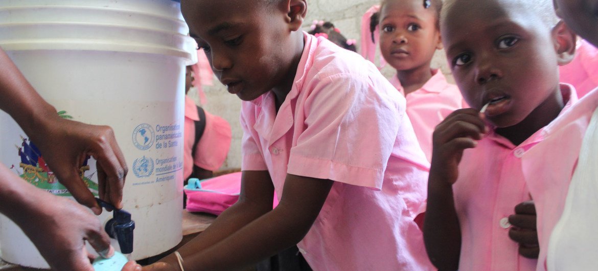 一群海地儿童正在学习怎样正确地洗手，以预防霍乱。