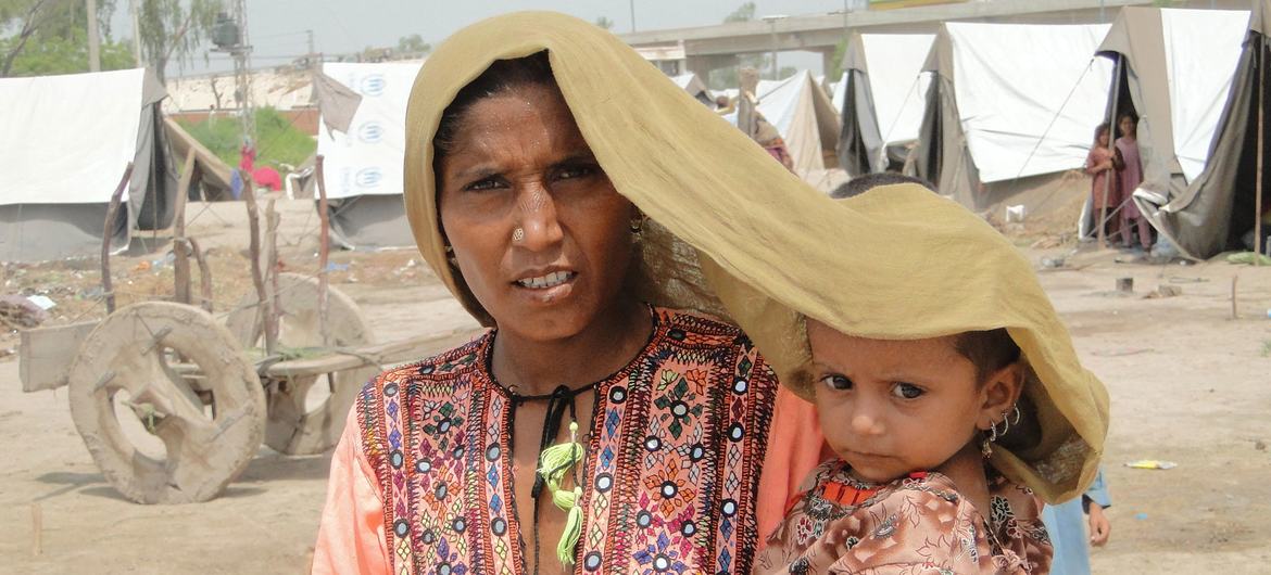 在巴基斯坦信德省，一位母亲试图为她四岁的女儿遮挡烈日。