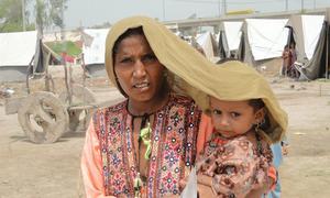 In Sindh province, Pakistan, a mother tries to shield her four-year-old daughter from scorching heat.