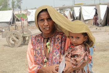 在巴基斯坦信德省，一位母亲试图为她四岁的女儿遮挡烈日。