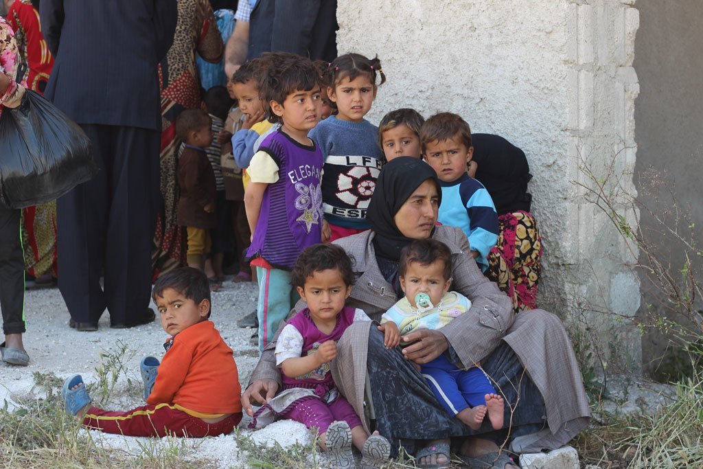 Une femme et ses enfants attendent devant un centre médical dans le village d'Al-Radwanieh, dans la zone rurale d'Alep, en Syrie.
