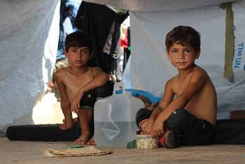 طفلان سوريان في خيمة مؤقتة على الطريق السريع في الجزء الغربي من مدينة حلب، سوريا