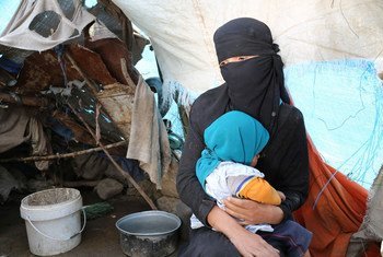 On 8 August 2016 in Yemen, an internally displaced woman sits with her daughter in front of her makeshift shelter in the Tharawan IDP camp on the outskirts of Sana’a. By 11 August 2016, over 2.8 million internally displaced persons (IDPs) had fled their h