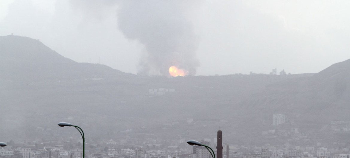 A large ball of fire and plume of smoke – resulting from an air strike that hit a military site on Faj Attan Mountain, Yemen, high above Sana’a, the capital – rises skyward and begins to spread over the city below.