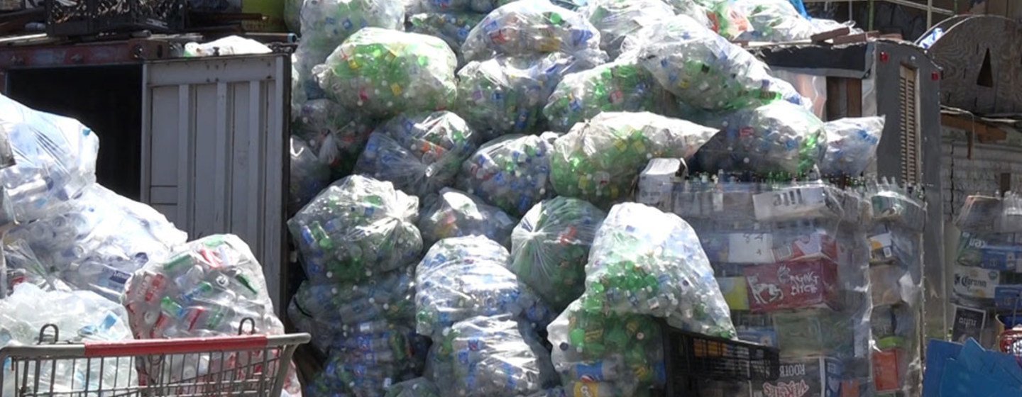 Latas y botellas recolectadas en espera de ser recogidas por las compañías distribuidoras en el centro de reciclaje de Sure We can. Foto ONU