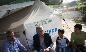 UN High Commissioner for Refugees Filippo Grandi (centre) talks with a Syrian family at the Lagkadikia site in Northern Greece.