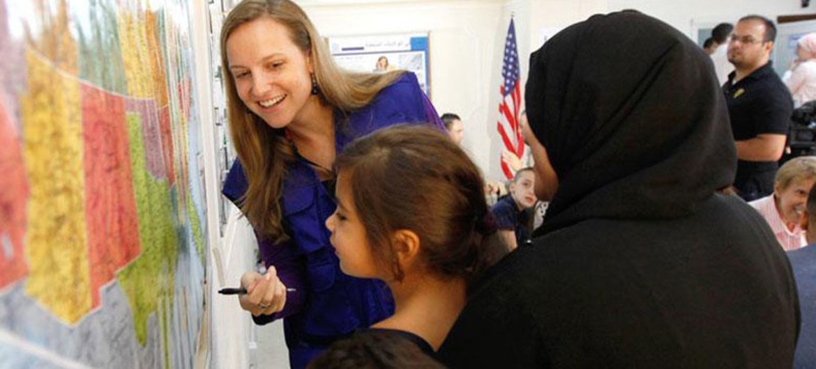 叙利亚难民儿童在国际移民组织的官员指导下了解美国地图。国际移民组织/Victoria Hazou