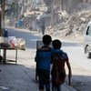 On 24 August 2016, two children walk arm in arm down a war damaged street in Aleppo, Syria.