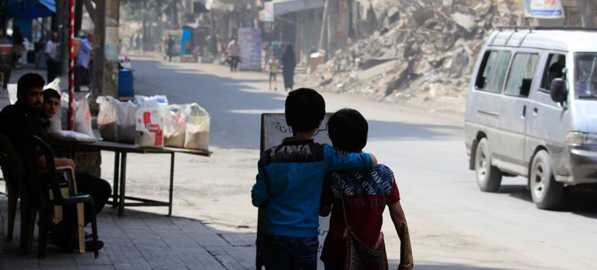 On 24 August 2016, two children walk arm in arm down a war damaged street in Aleppo, Syria.