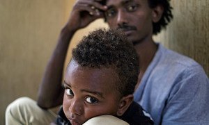 In Libya, Addis, holding his 30-month-old son, Lato, sits in a cell at the Alguaiha detention centre, which houses illegal migrants apprehended while attempting the dangerous voyage across the Mediterranean Sea.