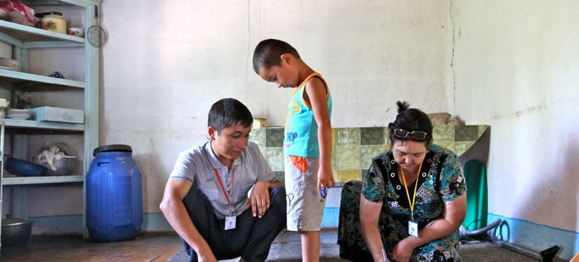 Сотрудник  органов  здравоохранения измеряет  и вносит в базу данных  рост и вес  трехлетнего  Эрлана в  Узбекистане.  Фото ЮНИСЕФ