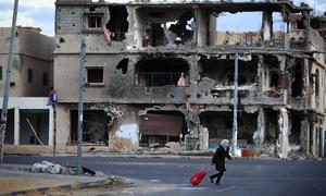 A girl crosses a street in the city of Sirte, Libya. Much of the city was destroyed during weeks of fighting there.