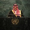 A Saudi Arabian official in traditional dress speaks at a podium with the United Nations emblem.