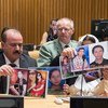 Participants at a UNODC event in New York hold up photos of their missing loved ones.