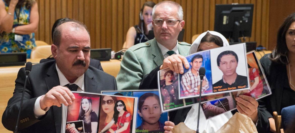 Participants at a UNODC event in New York hold up photos of their missing loved ones.