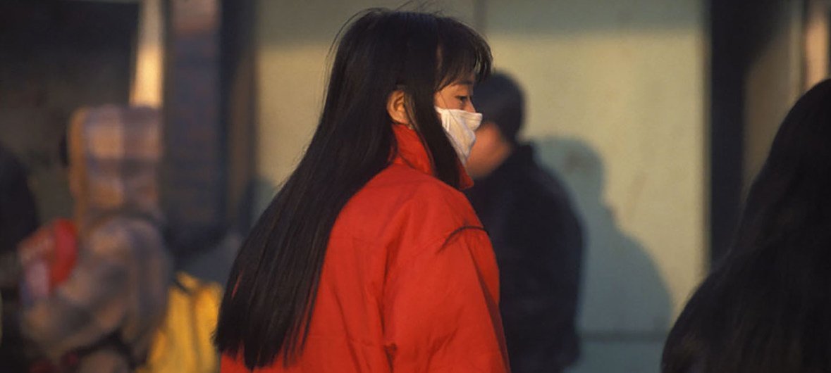 Una mujer en China utiliza un tapabocas.