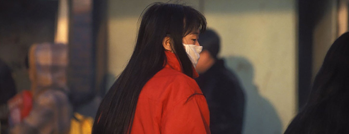 Una mujer en China utiliza un tapabocas.