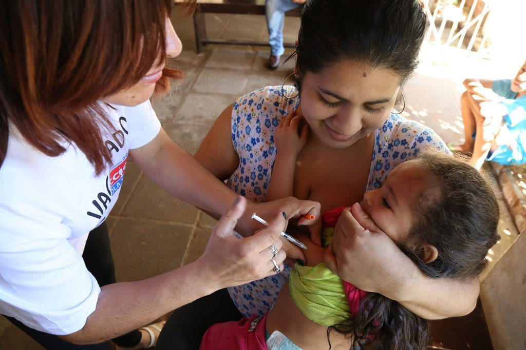 Une infirmière administre un vaccin contre la rougeole à un enfant au Paraguay.