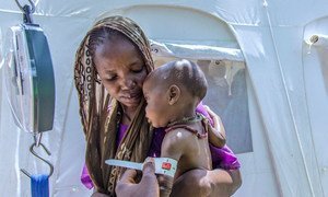 An Internally displaced person (IDP) brings her son for Severe Acute Malnutrition (SAM) treatment at one of the health centres UNICEF is supporting in Banki IDP camp, Borno state, northeast Nigeria.