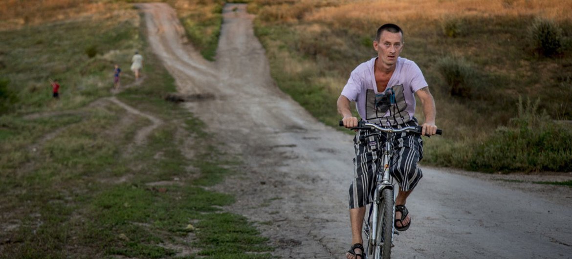 Un homme circule à vélo dans le village de Novosvetlovka, dans l'est de l'Ukraine (archives). Photo HCR/Petr Shelomovskiy