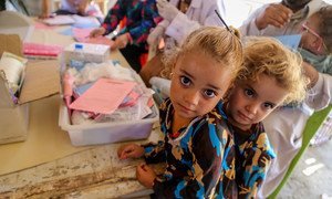 Two girls wait in line at a temporary medical centre in Bzebiz Displacement Camp in Baghdad, Iraq.