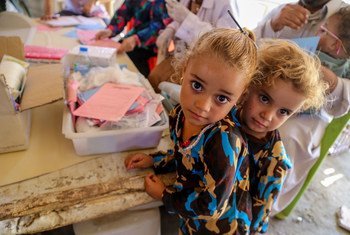 Two girls wait in line at a temporary medical centre in Bzebiz Displacement Camp in Baghdad, Iraq.