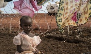 Niema, 3 ans, et assise pendant que sa mère lave des vêtements le long d'un grillage du site de protection des civils de l'ONU qui héberge plus de 30.000 personnes déplacées à Wau, au Soudan du Sud.