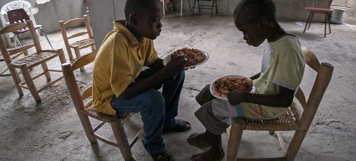 طفلان يتناولان  الطعام في كنيسة في كروا دي بوكيه، هايتي،   شرق العاصمة بورت أو برنس. المصدر: اليونيسف / باهارى كوداباندا
