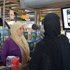 约旦扎阿塔里难民营的一位叙利亚难民正看着虹膜扫描仪，她能通过扫描眼睛为在商店里买的东西付钱。