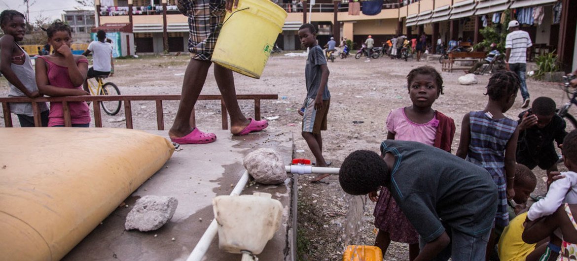 2016年10月9日，海地飓风灾区的一些灾民临时住在附近的一所高中内。联合国儿童基金会在校内安装了水带，提供清洁饮用水。儿基会图片/Roger LeMoyne