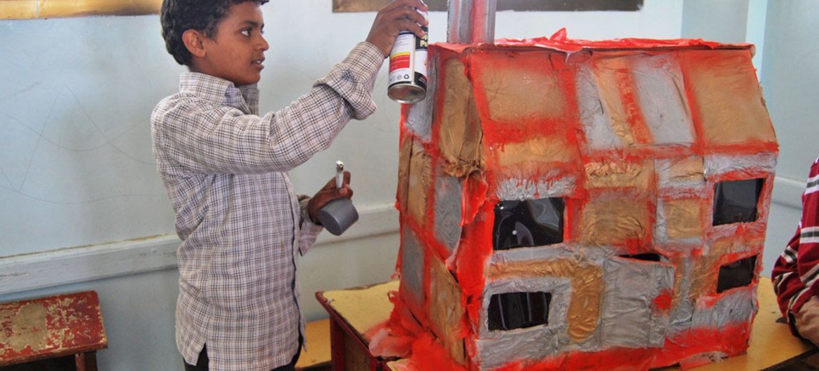 Como parte de su tratamiento para la salud mental, un niño desplazado esculpe una réplica de su casa dañada en Sa'ada, Yemen. 