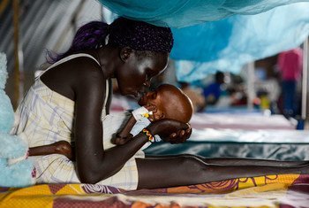 In South Sudan, a mother kisses her baby, who is suffering from severe acute malnutrition with complications, including tuberculosis.