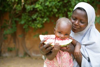 A mother holds her child while eating a slice of watermelon in Niamey the capital of Niger.