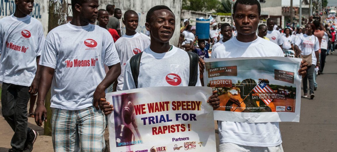 लाइबेरिया में बलात्कार विरोधी पोस्टरों के साथ पुरुषों का मार्च