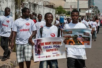 लाइबेरिया में बलात्कार विरोधी पोस्टरों के साथ पुरुषों का मार्च