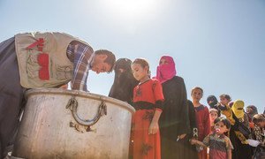Iraqi women and children displaced from the Mosul corridor line up to recieve food in Debaga Displacement Camp in Erbil Governorate.